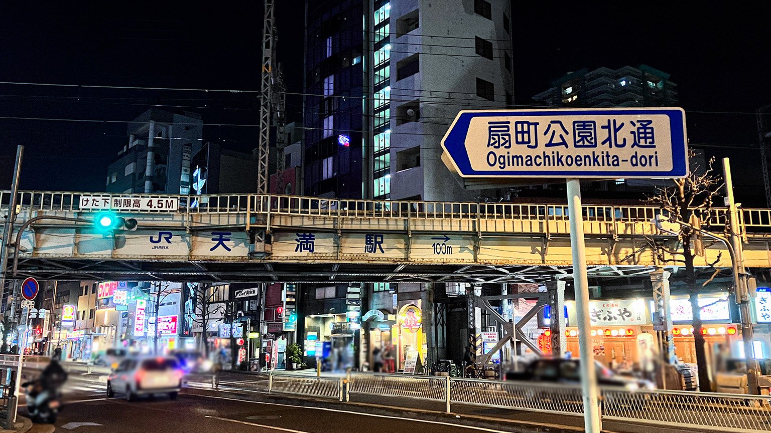 天満駅付近の大阪環状線の高架と扇町公園北通の看板の写真