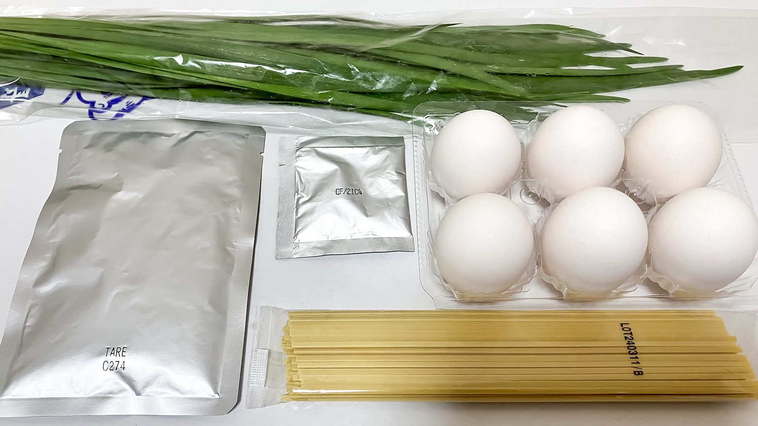 台湾まぜそばの材料の写真、中華麺、肉だれ、魚粉、ニラ、卵